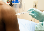 Photo of an individual being given a vaccine by injection